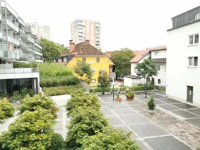 an empty courtyard in a city with buildings at City centre studio with a balcony and free parking in Ljubljana