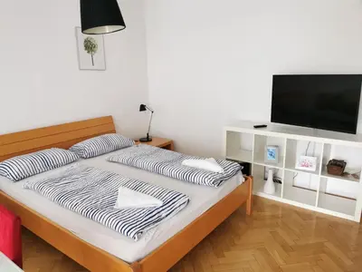 a bedroom with a bed with a flat screen tv at City centre studio with a balcony and free parking in Ljubljana