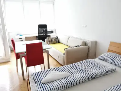 a living room with a couch and a table at City centre studio with a balcony and free parking in Ljubljana