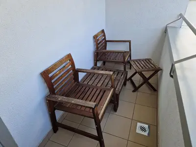 two wooden chairs sitting next to a wall at City centre studio with a balcony and free parking in Ljubljana