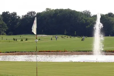 a fountain in the middle of a golf course with a pond at Apartment Pika in Moravske Toplice