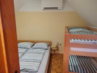 two bunk beds in a small room with a bed at Apartment Pika in Moravske Toplice