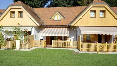 a house with a wooden fence and a yard at Apartment Pika in Moravske Toplice