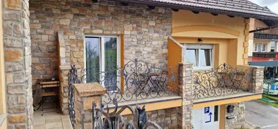 a stone house with a balcony with a table at Hotel SAMARIN Črnomelj in Črnomelj