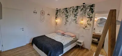 a bedroom with a bed with pink pillows on it at Hotel SAMARIN Črnomelj in Črnomelj