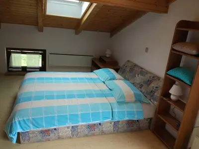 a bedroom with a bed with a blue and white comforter at Apartment Lapanja in Slappe dʼIdria