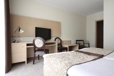 a hotel room with a bed and a desk with a television at Hotel Mangart in Bovec