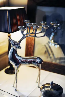 a metal drink holder with wine glasses on a table at Lesar Hotel Angel - Member of Hip Hotels in Ljubljana