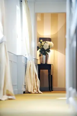 a vase of flowers on a table next to a window at Lesar Hotel Angel - Member of Hip Hotels in Ljubljana