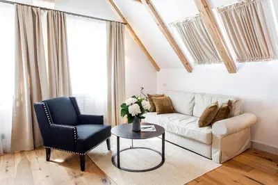 a living room with a couch and a chair and a table at Lesar Hotel Angel - Member of Hip Hotels in Ljubljana