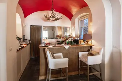 a kitchen with a bar with a red ceiling at Lesar Hotel Angel - Member of Hip Hotels in Ljubljana