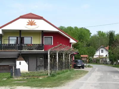 a red and white house on the side of a road at Atera in Banovci