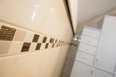 a bathroom with tiles on the wall and a cabinet at Holiday House Klemenčič in Bohinj