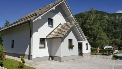 a small white house with a large roof at Holiday House Klemenčič in Bohinj