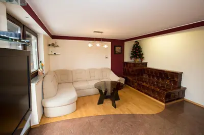 a living room with a white couch and a christmas tree at Holiday House Klemenčič in Bohinj