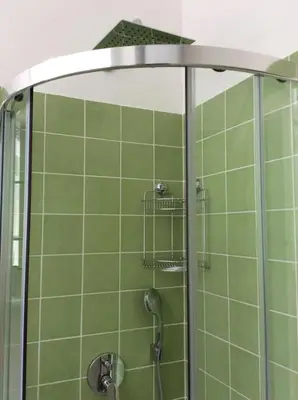 a shower with green tiles in a bathroom at Vila Rogaška in Rogaška Slatina