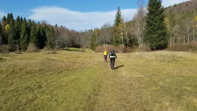 two people riding bikes on a grass field at Zidanica Ravbar in Uršna Sela