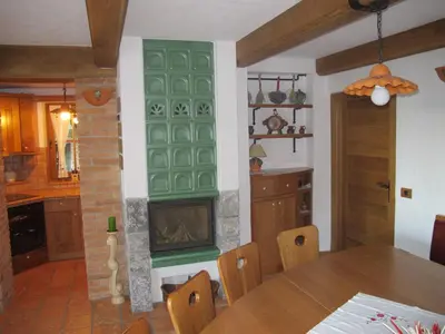 a living room with a fireplace and a dining room table at Zidanica Ravbar in Uršna Sela