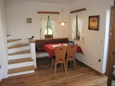 a dining room with a red table and chairs at Zidanica Ravbar in Uršna Sela