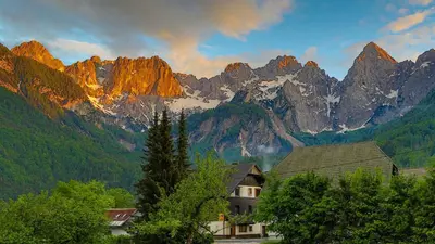 a mountain range with a house in front of it at Apartments in Villa Flora in Kranjska Gora