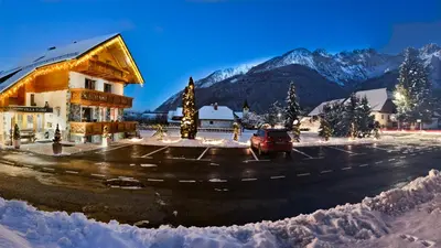 a car parked in a parking lot with snowy mountains at Apartments in Villa Flora in Kranjska Gora