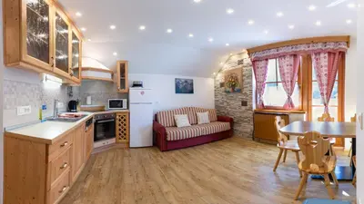 a kitchen and living room with a couch and a table at Apartments in Villa Flora in Kranjska Gora
