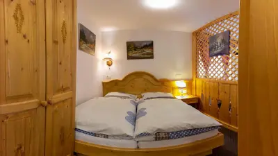 a bedroom with a wooden bed in a room at Apartments in Villa Flora in Kranjska Gora