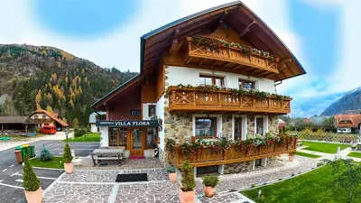 a building with a balcony with flowers on it at Apartments in Villa Flora in Kranjska Gora