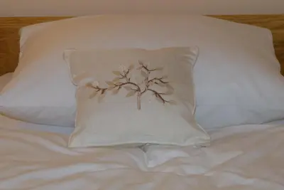 a pillow with a tree on it on a bed at Guest House Eco Vila Mila in Rogaška Slatina