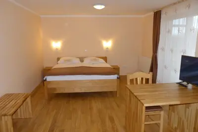 a bedroom with a bed and a desk and a television at Guest House Eco Vila Mila in Rogaška Slatina