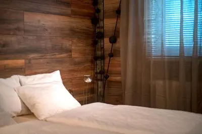 a bedroom with a bed with a wooden wall at Cute sunny apartment KOD1 in Ljubljana