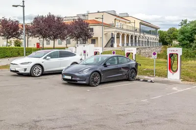 two cars are parked in a parking lot at Casino & Hotel ADMIRAL Kozina in Kozina