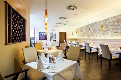 a dining room with white tables and chairs at Casino & Hotel ADMIRAL Kozina in Kozina