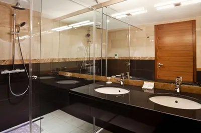 a bathroom with three sinks and a shower at Casino & Hotel ADMIRAL Kozina in Kozina