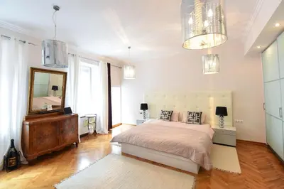 a bedroom with a bed and a mirror and a dresser at Neoclassical Luxury Apartment Ljubljana in Ljubljana