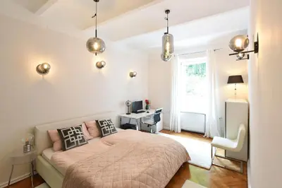 a bedroom with a bed and a desk and a window at Neoclassical Luxury Apartment Ljubljana in Ljubljana