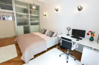 a bedroom with a bed and a desk with a computer at Neoclassical Luxury Apartment Ljubljana in Ljubljana