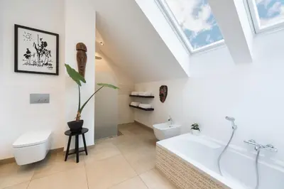 a bathroom with a tub and a toilet and a sink at Bled Apartment Kirsch in Bled