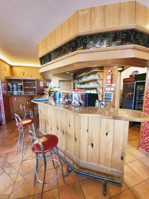 a kitchen with a counter with stools and a bar at Hostel Novak in Novo Mesto