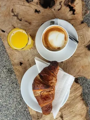 a cup of coffee and a pastry on a table at Hostel Novak in Novo Mesto