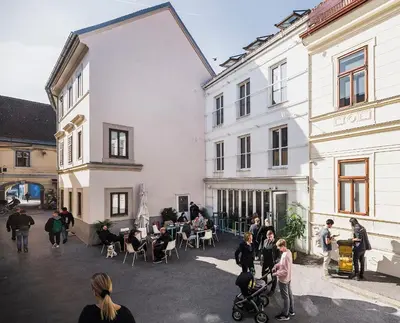 a group of people standing outside of buildings at Art Hotel in Ljubljana
