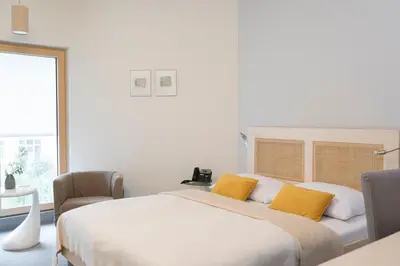 a bedroom with a large white bed with yellow pillows at Art Hotel in Ljubljana