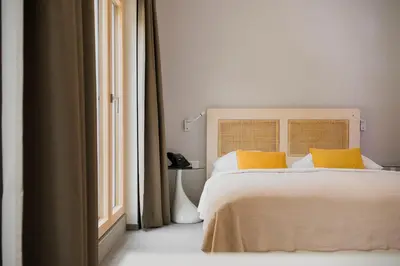 a bedroom with a bed with yellow pillows and a window at Art Hotel in Ljubljana