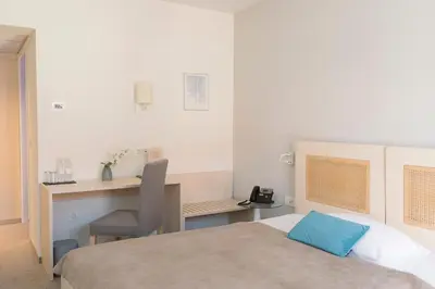 a bedroom with a bed and a desk with a chair at Art Hotel in Ljubljana