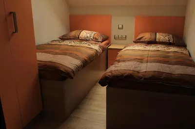 two twin beds in a small room with at Apartments Villa Dov in Bohinj