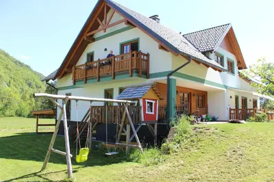 a house with a playground in front of it at Apartments Villa Dov in Bohinj