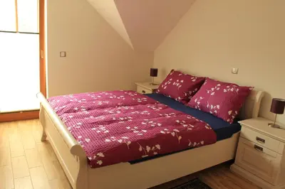 a bedroom with a bed with red sheets and a window at Apartments Villa Dov in Bohinj