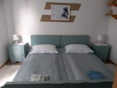 a bedroom with a bed with two night stands and two lamps at Apartment Mlinarjeva domačija in Kobarid