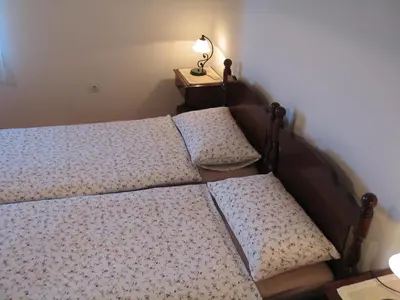 a bedroom with two beds and a table with a lamp at Tourist Farm Žvanč in Kobarid