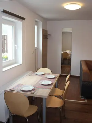 a dining table and chairs in a living room at Apartment Pri nama in Bovec